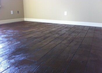 Finished dark stained hardwood floor in a room in Ephrata, Pennsylvania. Dark stained hardwood floor in a room with beige walls and white baseboards.