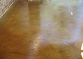 Exterior acid stained concrete floor in a residential area, showing a glossy, decorative finish. Finished exterior acid stained concrete floor in a residential setting.
