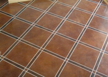 Interior acid stained concrete floor with grid pattern in a residential space. Finished acid stained concrete floor with grid pattern and brown tones.
