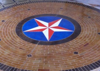Decorative concrete floor with a star emblem, part of a custom engraving project. Decorative concrete floor with a star emblem in the center, surrounded by brick patterns.