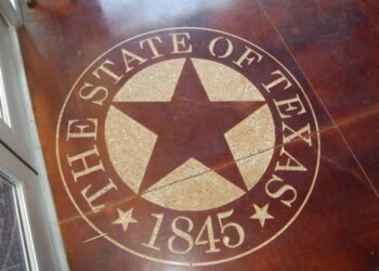 Engraved Texas state seal on a wooden surface, part of a custom concrete project in Texas. Texas state seal with star and 'The State of Texas 1845' engraved on a wooden surface.