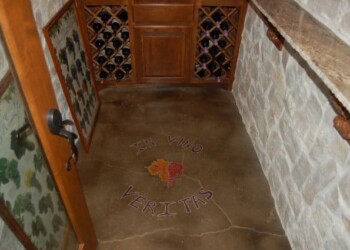 Custom engraved tile floor with Ohio map in a wine cellar or bar area. Decorative tile floor with painted map of Ohio and 'In Ohio We Veriths' text.