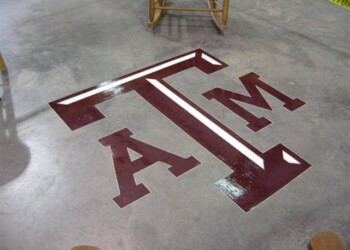 Concrete floor with Texas A&M logo painted in maroon and white, part of a custom engraving project. Custom maroon and white Texas A&M logo painted on concrete floor.