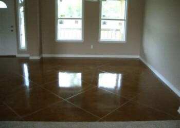 Interior acid staining project showing a polished, brown concrete floor in a home. Finished interior with acid-stained concrete floor in a residential room.