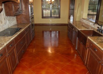 Kitchen with acid-stained concrete floor and wooden cabinets in a home. Kitchen with polished acid-stained concrete floor and wooden cabinets.