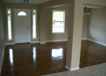 Newly finished home interior with polished concrete floors and natural light. Interior view of a newly finished home with polished concrete floors and large windows.
