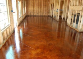 Newly acid stained concrete floor in a residential interior under construction. Interior of a room with freshly acid stained concrete floor in a new construction home.