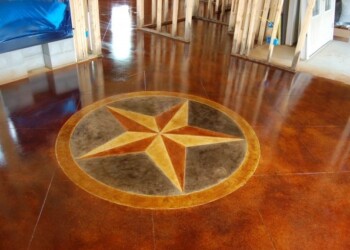 Polished concrete floor with a star design in a home during interior acid staining. Decorative star design in polished concrete floor in a residential interior.