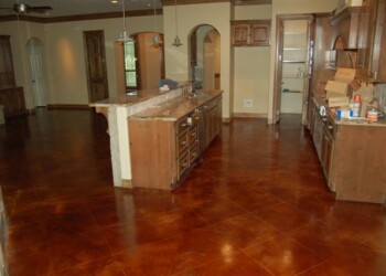 Kitchen with newly acid stained concrete floor in a home in Euless, Texas. Interior view of a kitchen with freshly acid stained concrete floor in a residential home.