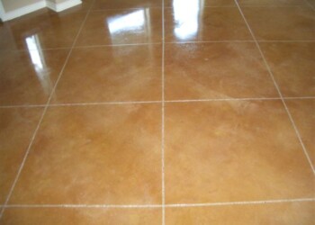 Finished acid-stained concrete floor with a warm, earthy tone in a home. Close-up of a polished acid-stained concrete floor in a residential interior.