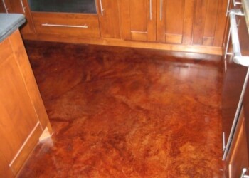 Kitchen with newly acid stained concrete floor and wooden cabinets. Finished acid stained concrete floor in a kitchen with wooden cabinets.