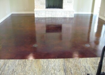 Interior acid stained concrete floor in a living room, showing a rich, dark finish. Polished concrete floor with a dark acid stain finish in a living room.