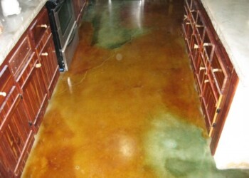 Kitchen with acid stained concrete floor in a home in Eads, Tennessee. Finished acid stained concrete floor in a kitchen with wooden cabinets.