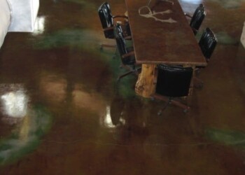Conference room with a polished acid stained concrete floor and a wooden table. Concrete floor with a polished acid stain finish in a conference room.