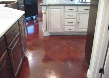 Kitchen with a polished acid-stained concrete floor in a reddish-brown hue. Interior view of a kitchen with a polished acid-stained concrete floor in a reddish-brown color.