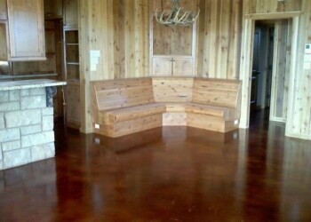 Wooden interior with curved bench and polished hardwood floor in a rustic setting. Interior of a wooden room with a curved wooden bench and polished hardwood floor.