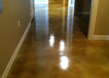 Interior acid stained concrete floor in a home, showing a glossy finish and warm color tones. Finished interior concrete floor with acid stain in a residential home.