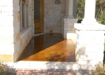 Exterior acid stained concrete porch at a Texas home, showing a rich, glossy finish. Finished exterior concrete porch with acid stain in a residential Texas home.