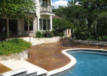 Acid stained concrete patio surrounds the pool at a Texas home. Concrete patio with acid stain finish around a swimming pool at a residential home.