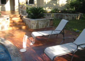 Finished acid stained concrete patio with lounge chairs and landscaped yard in Eustis, Florida. Concrete patio with acid stain finish, lounge chairs, and landscaped yard in Eustis, Florida.