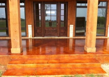 Exterior concrete porch with acid stain finish and wooden steps in a residential home. Finished exterior concrete porch with acid stain finish and wooden steps in a residential setting.