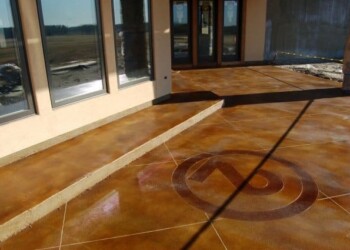 Finished decorative concrete patio with logo outside a commercial building. Decorative concrete with a circular logo on a patio outside a building.