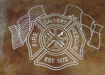 Chalk drawing of Fire Calvert Rescue emblem with flags on a brown surface. Chalk drawing of Fire Calvert Rescue emblem with flags on a brown surface.