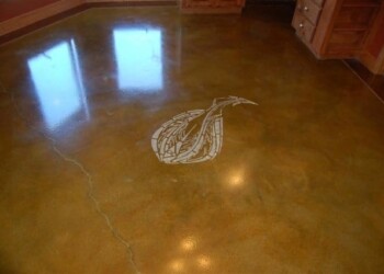 Polished concrete floor with engraved eagle logo in a residential setting. Decorative eagle logo engraved on polished concrete floor.