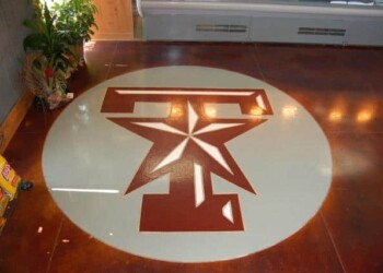 Concrete floor with a custom engraved logo in a business or commercial space. Custom engraved logo on polished concrete floor in a business setting.