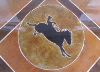 Custom dog logo engraved on tile floor, part of a concrete work project in Eads, Tennessee. Custom engraved logo of a dog with a stick inside a circle on tile floor.