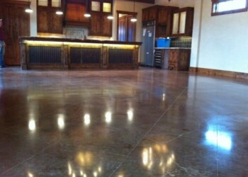 Polished concrete floor in a kitchen with wooden cabinets and a bar area. Polished concrete floor in a kitchen with wooden cabinets and a bar area.