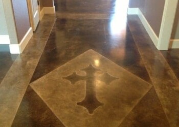 Custom engraved concrete floor in a hallway, showcasing a cross design. Decorative concrete floor with a cross-shaped design in the center.