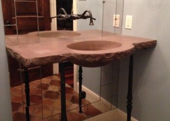 Bathroom vanity with pink marble countertop and black metal legs in a home. Bathroom vanity with a pink marble countertop and black metal legs in a home.