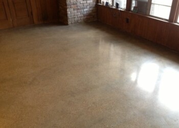 Polished concrete floor in a room with brick and wood walls. Finished polished concrete floor in a room with brick and wood walls.