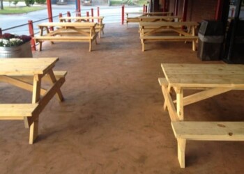 Outdoor seating with new wooden picnic tables at ECD Concrete in Oklahoma. Empty outdoor seating area with wooden picnic tables at ECD Concrete in Oklahoma.
