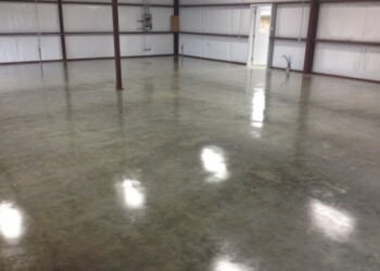 Finished acid-stained concrete floor inside a warehouse in ECD Concrete's shop. Interior of a concrete building with a polished acid-stained floor in ECD Concrete's shop.