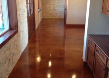 Interior acid staining on polished concrete in a dining room in Eads, Tennessee. Polished concrete floor in a dining area with stone walls and wooden accents.