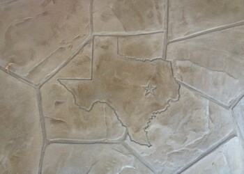 Close-up of stamped concrete featuring Texas shape and star in beige color. Stamped concrete with Texas shape and star design in beige tones.