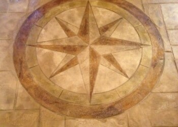 Stamped concrete floor with a compass rose pattern in a residential setting. Decorative compass rose design in stamped concrete floor.