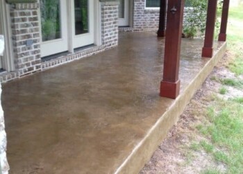 Stamped concrete porch with brick exterior and wooden support beams in Eads, Tennessee. Concrete porch with stamped overlay and brick house exterior in Eads, Tennessee.