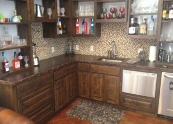 Home bar kitchen with glassware and granite countertops in Eads, Tennessee. Kitchen with dark wood cabinets, glassware, and a granite countertop in a home bar setting.