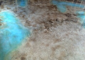 Interior acid stained concrete floor with blue and brown tones in a residential setting. Close-up of a finished acid stained concrete floor with blue and brown hues.