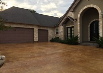 Finished acid stained concrete driveway at a residential home in Euless, Texas. Concrete driveway with acid stain finish outside a residential home in Euless, Texas.