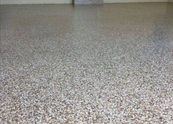 Epoxy-coated garage floor in a residential garage, clean and polished. Finished garage floor with epoxy coating in a residential garage.