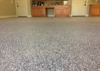 Garage floor coated with a speckled gray and black finish in a residential garage. Finished garage floor coating with speckled gray and black finish in a residential garage.