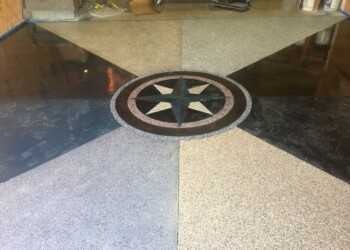 Decorative concrete floor with a star emblem, part of a garage or commercial space. Decorative concrete floor with a star emblem in the center, part of a garage or commercial space.