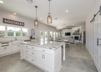 Kitchen with white cabinets, granite countertops, and pendant lighting in Southern. Bright, modern kitchen with white cabinets and granite countertops in a home in Southern.