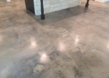 Sealed and waxed concrete floor in a commercial area, showing a smooth, polished surface. Finished sealed and waxed concrete floor in a commercial space.