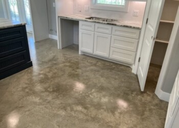Finished polished concrete floor in a kitchen in Eads, Tennessee. Polished concrete floor in a kitchen with white cabinets and granite countertop.