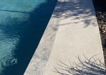 Pool deck with spray cool deck finish in a backyard in Euless, Texas. Concrete pool deck with spray cool deck finish in a backyard.